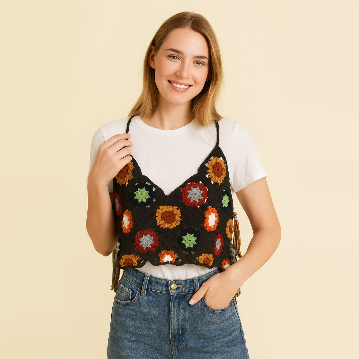 Model styling the colorful granny square vest layered over a white t-shirt for a casual crochet tank top look
