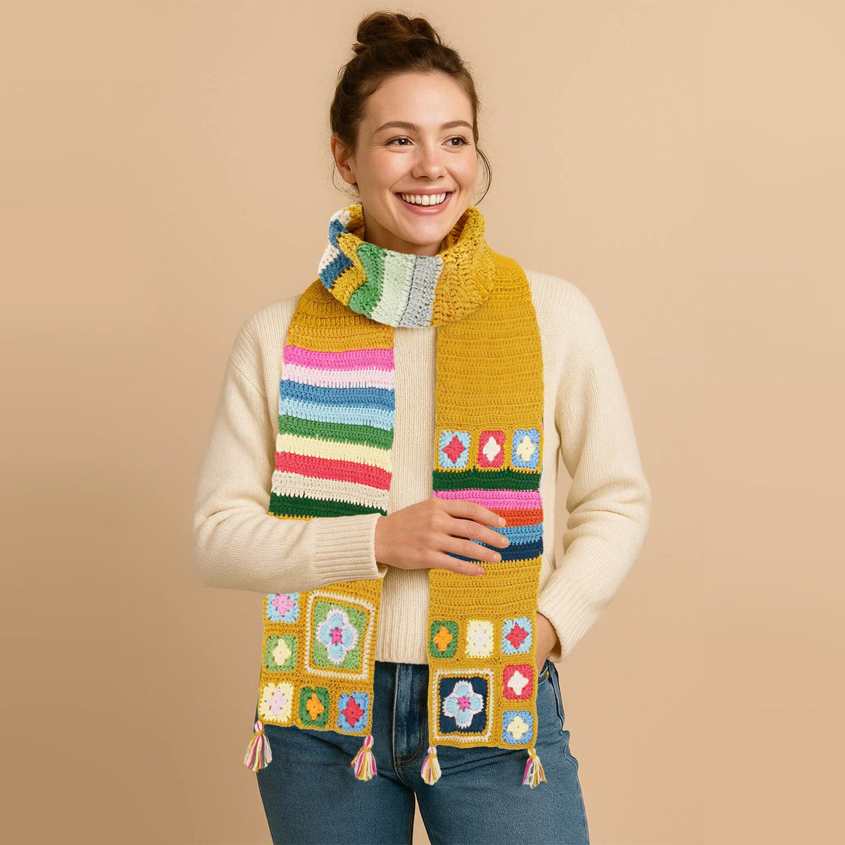 Woman wearing a golden granny square crochet scarf with colorful patterns
