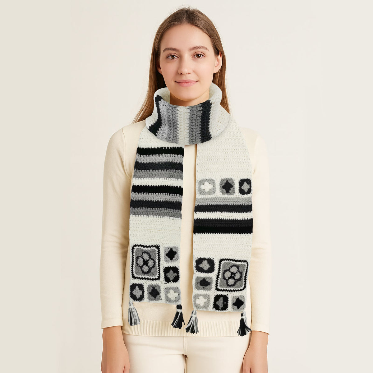 Woman wearing an ivory granny square crochet scarf with colorful patterns