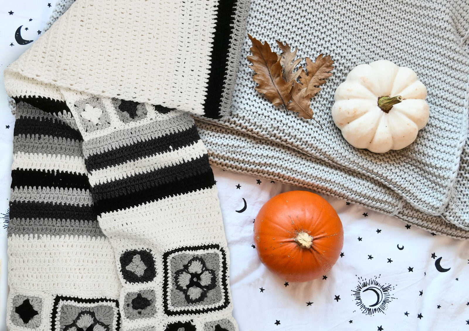 Ivory granny square crochet scarf displayed with knitted blankets and pumpkins in a cozy setting