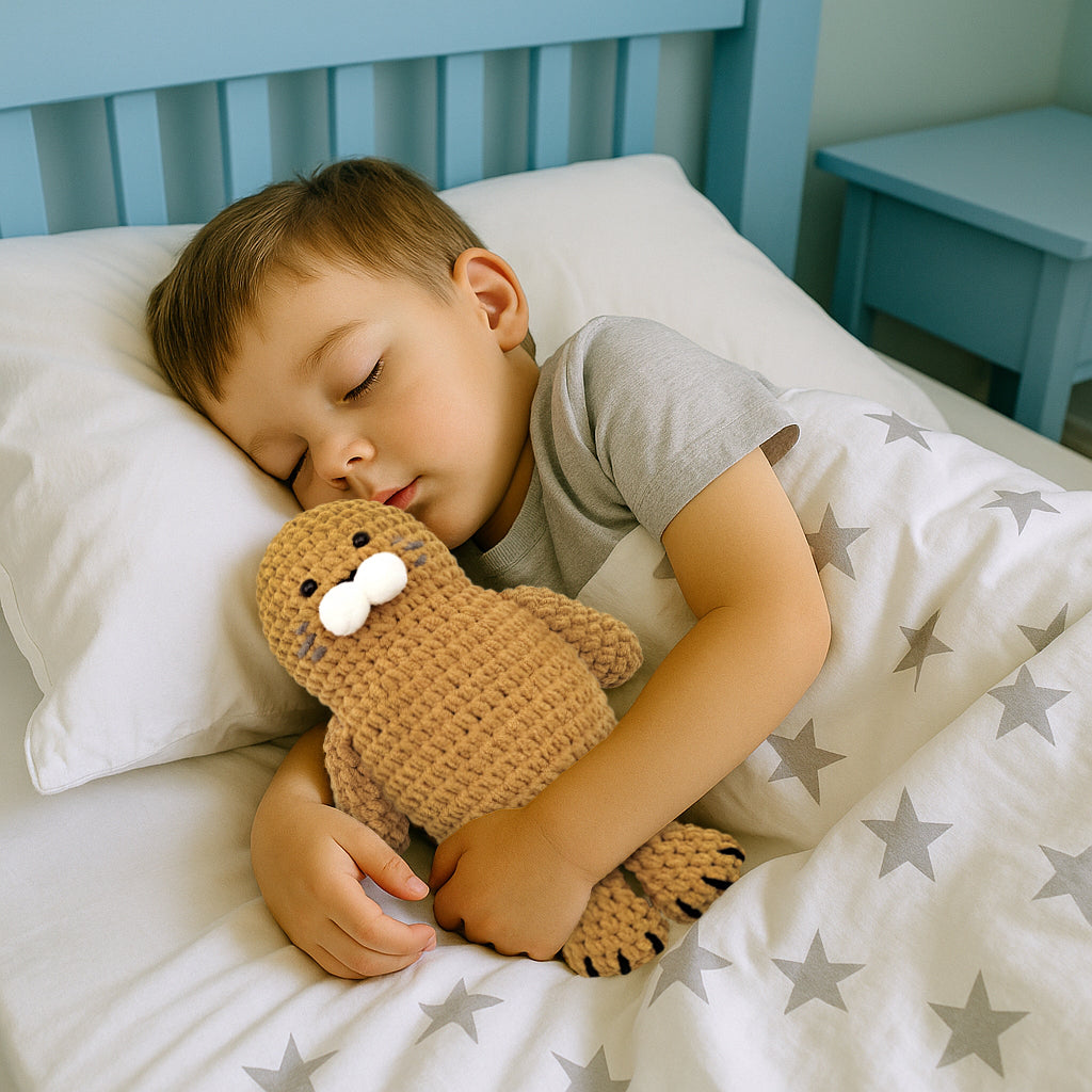 Sleeping boy cuddling the soft finished Hugging Seal crochet sea animal plushie