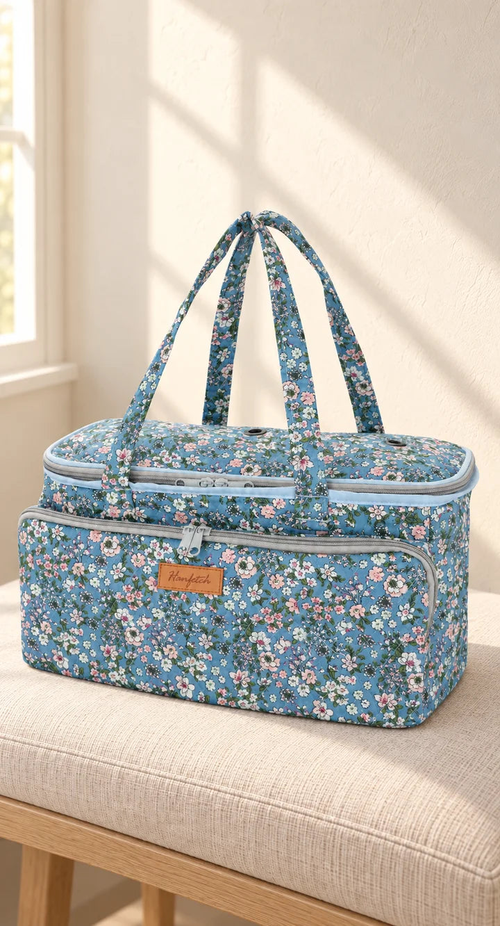 Borsa portafilati blu a fiori in un ambiente caldo illuminato da una finestra, con i manici interamente visibili