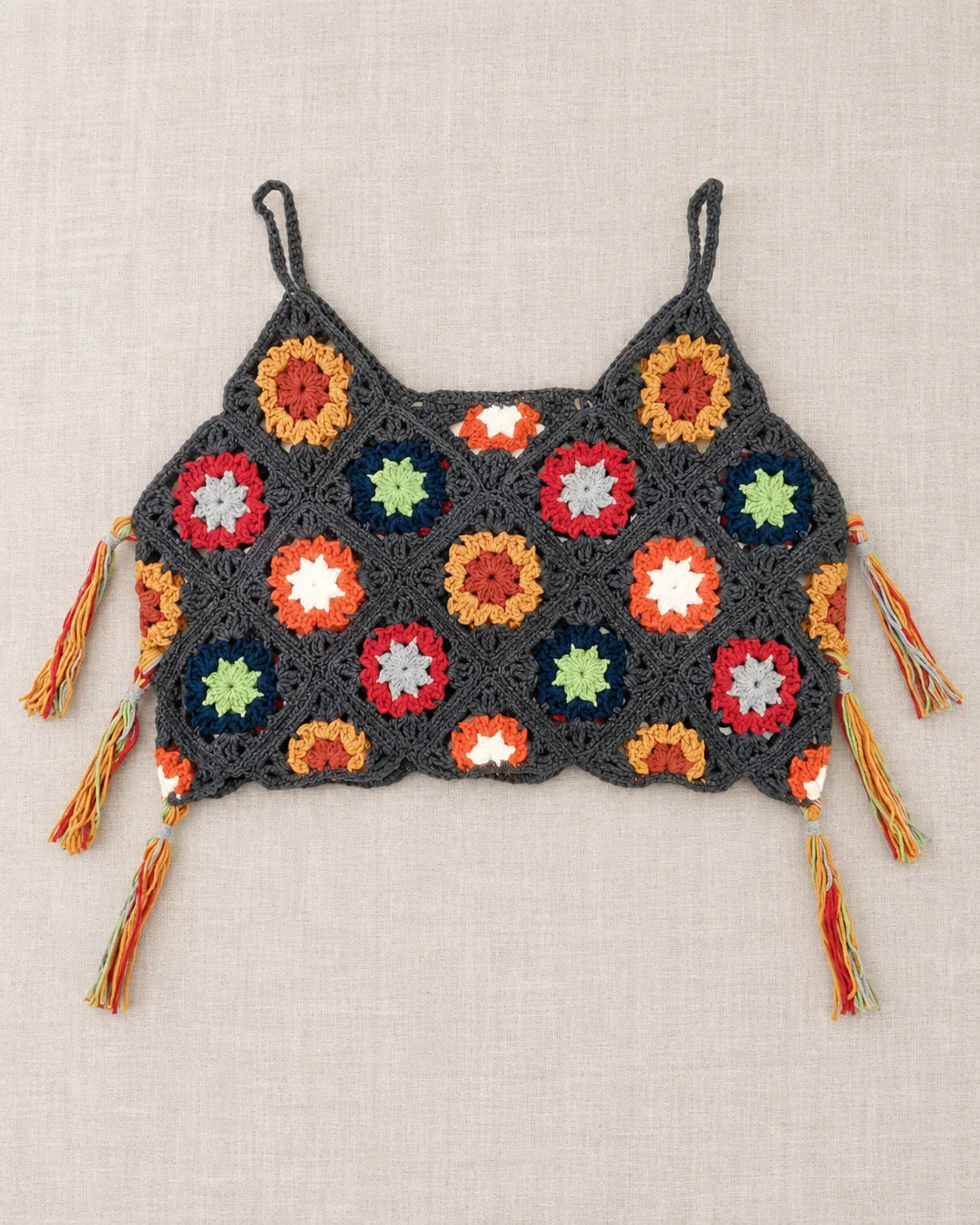 Granny square crochet tank top design with colourful motifs and tassel details