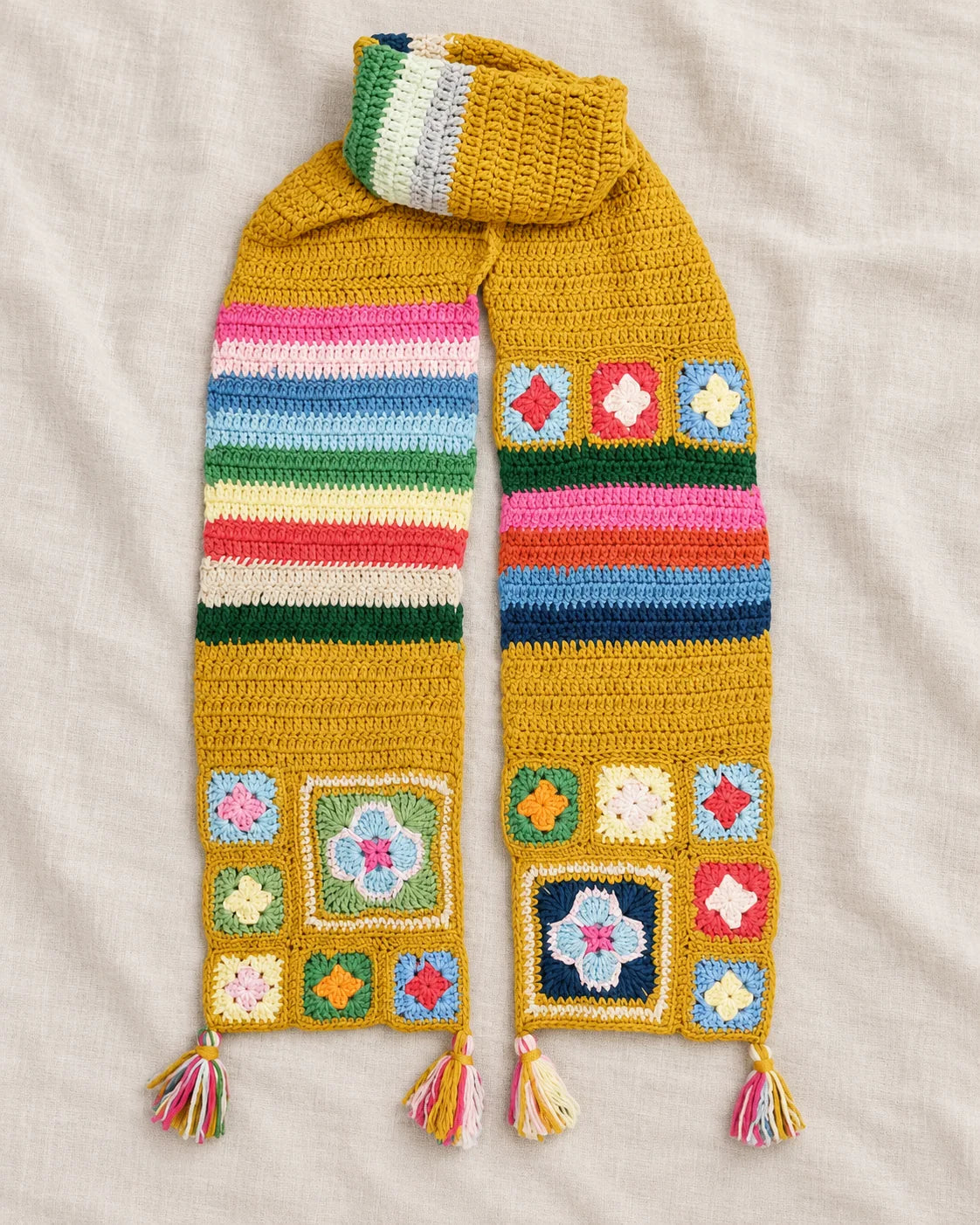 Granny square crochet scarf with repeated colourful motifs and tassel finishing