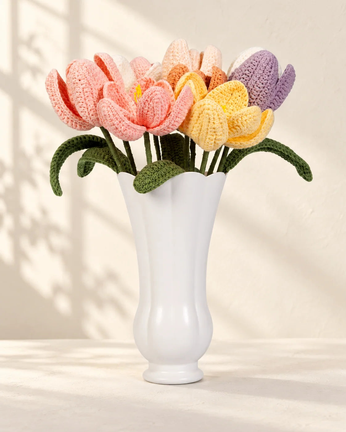 Multicoloured crochet tulips with green leaves and stems arranged as a bouquet
