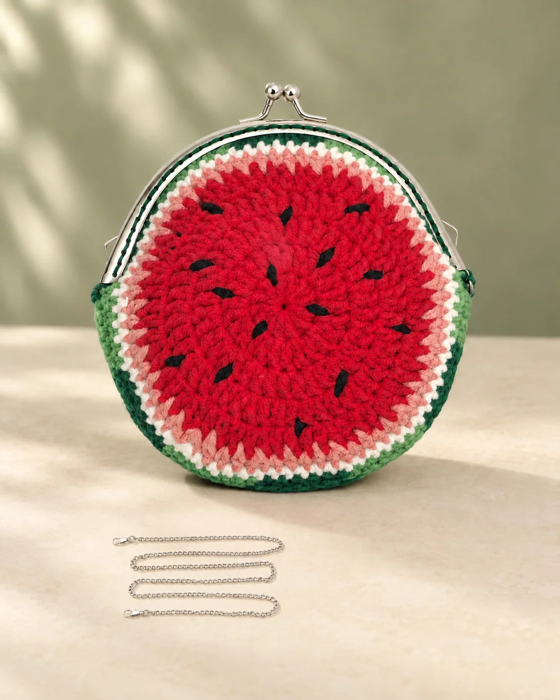Watermelon crochet coin purse with red yarn, green edging and black seed details